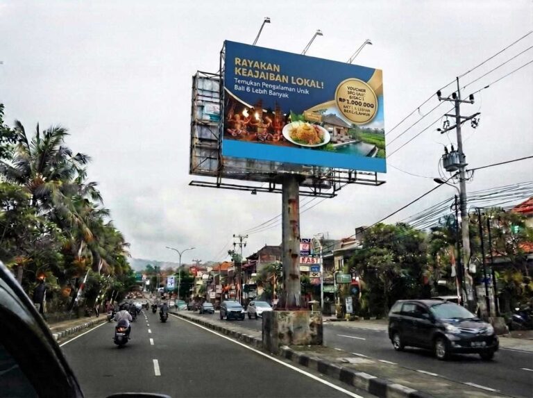 Pemasangan reklame outdoor bali berbentuk billboard vertikal yang kokoh di pinggir jalan raya.